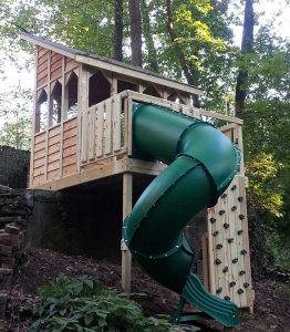 Adaptable fort design on seven foot slope (steepest yet!) with a rock climbing wall and enclosed spiral slide - Asheville Playgrounds