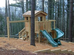 Cedar lap cabin on a steep slope with an attached swing beam and two separate slides - Asheville Playgrounds