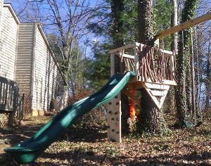 Rustic tree deck with swings and slide - Asheville Playgrounds